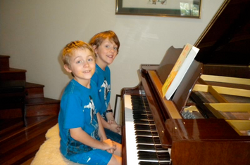 Two boys sitting at the piano